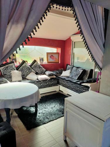 a living room with a couch with pillows on it at Villa piscine proche Futuroscope in Buxerolles