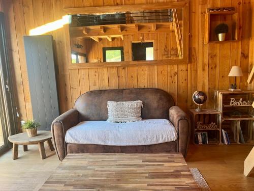 a living room with a couch in a wooden wall at La cabane du Broustic in Andernos-les-Bains