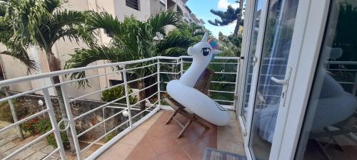 a room with a balcony with a swan chair at Coco Lux Studio Grand Baie in Grand Baie