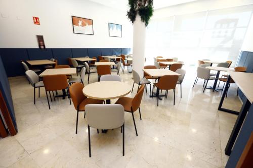un comedor con mesas y sillas en Travelodge Madrid Coslada Aeropuerto, en Coslada