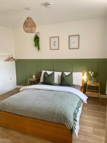 a bedroom with a large bed with a green headboard at Central, Chic Apartment in Bournemouth