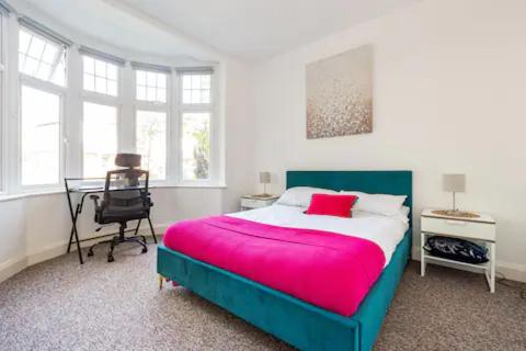 a bedroom with a large bed and a desk at Garden Flat in central location in London