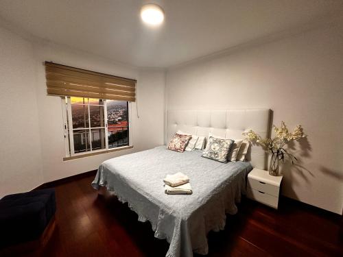 um quarto com uma cama branca e uma janela em SÃO GONÇALO APARTAMENTO em São Gonçalo