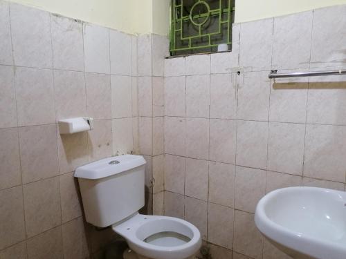 y baño con aseo y lavamanos. en Forest green Inn, en Kakamega