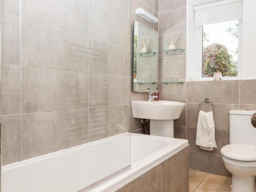 a bathroom with a tub and a sink and a toilet at 3 Skaigh View Cottages in Okehampton