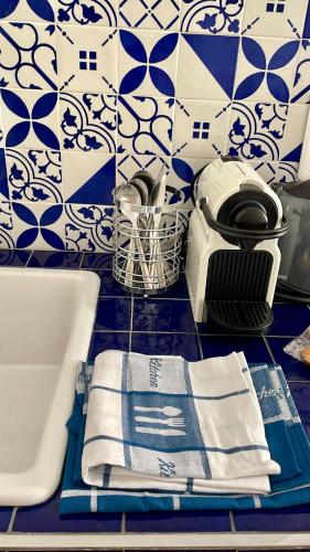La salle de bains est pourvue d'un lavabo et de carrelage bleu et blanc. dans l'établissement Appartement bleu l'union, à Beausoleil