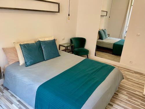 a bedroom with a large bed with blue pillows at Appartement bleu l'union in Beausoleil