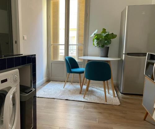 a living room with a table and two chairs at Appartement bleu l'union in Beausoleil