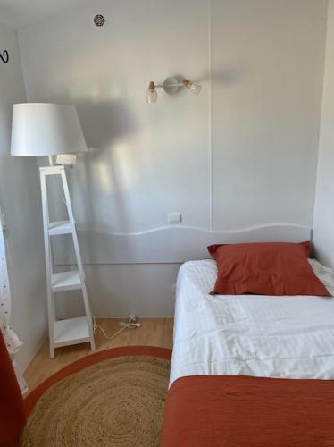 a bedroom with a bed and a ladder and a lamp at TINY HOUSE in Souvans