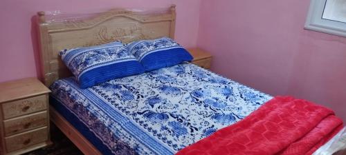 Cama con sábanas y almohadas azules y blancas en Tanger tanger tanja, en Tánger