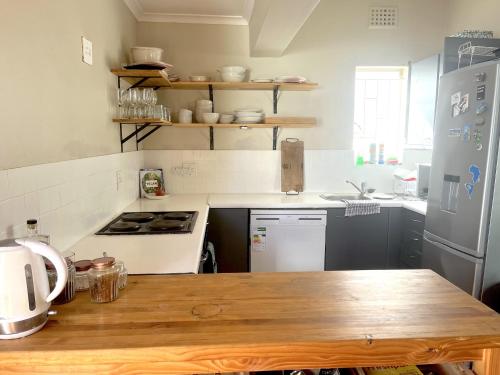 a kitchen with a wooden table and a refrigerator at Rondebosch loft in Cape Town