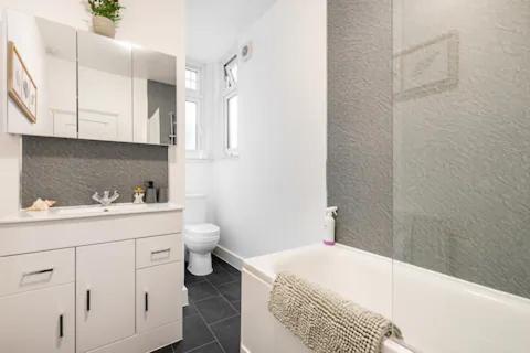 a bathroom with a tub and a toilet and a sink at Garden Flat in central location in London