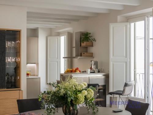 a kitchen with a table with a vase of flowers at Aparttime Palma mit 3 MeerBlick Dach-Terrassen in Palma de Mallorca