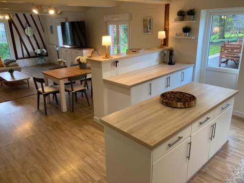 une cuisine avec des armoires blanches et une table et une salle à manger dans l'établissement Les Bottes à la Plage, à Le Bourg-Dun