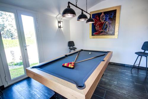 a pool table in a living room with at Chambres d'hôtes du Val d'Asson in Montaigu-Vendée