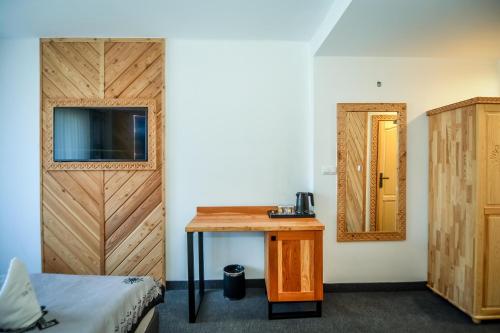 a room with a bed and a table and a mirror at My Tatra Residence in Zakopane