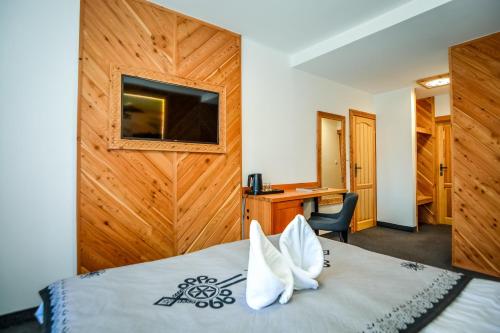 a hotel room with a bed with white pillows at My Tatra Residence in Zakopane
