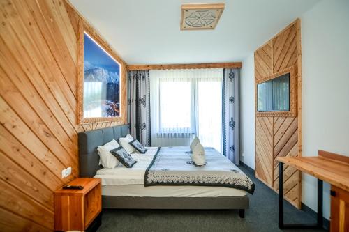 a bedroom with a bed in a room with a window at My Tatra Residence in Zakopane