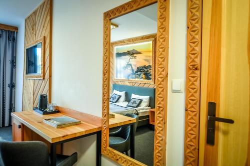 a mirror in a hotel room with a bed at My Tatra Residence in Zakopane