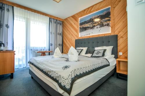 a bedroom with a large bed with white sheets and pillows at My Tatra Residence in Zakopane