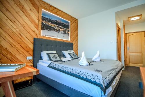 a bedroom with a bed and a wooden wall at My Tatra Residence in Zakopane