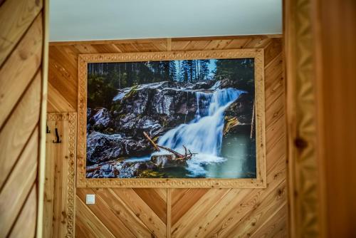 a picture of a waterfall on a wall in a room at My Tatra Residence in Zakopane