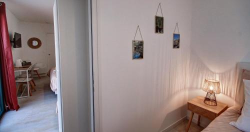 a bedroom with a white wall with pictures on it at Chambres d'hôtes du Val d'Asson in Montaigu-Vendée