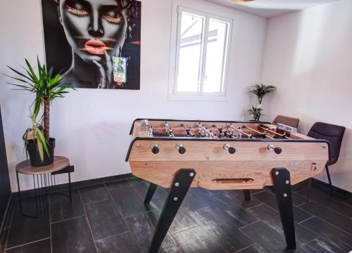 a room with a foosball table and a painting at Chambres d'hôtes du Val d'Asson in Montaigu-Vendée