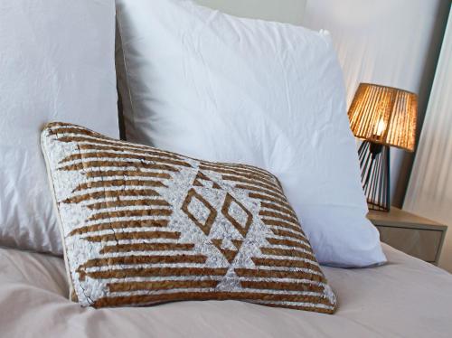 a brown and white pillow sitting on top of a bed at Chambres d'hôtes du Val d'Asson in Montaigu-Vendée
