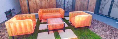 three orange chairs sitting on the grass in a yard at Chambres d'hôtes du Val d'Asson in Montaigu-Vendée