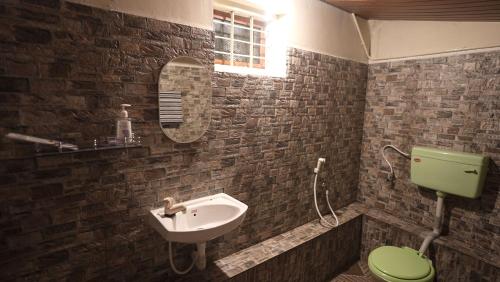 a bathroom with a green toilet and a sink at Qatsyir Horizon in Varagampadi