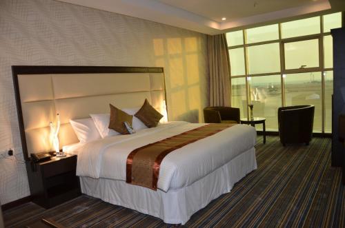 Habitación de hotel con cama grande y ventana en جولدن أرمادا جيزان Golden Armada Hotel, en Jazan