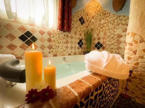a bathroom with two candles in a bath tub at Black Forest Hotel Todtnau in Todtnau