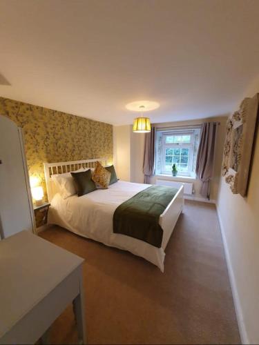 a bedroom with a large bed and a window at Station House in St Austell