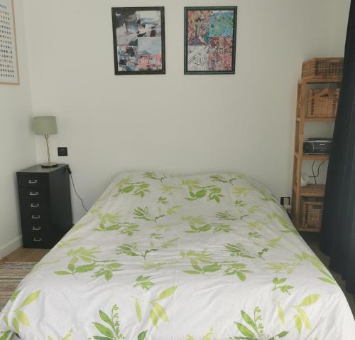 - un lit avec un couvre-lit blanc et des feuilles dans l'établissement Chambre meublée indépendante, à Charbonnières-les-Bains