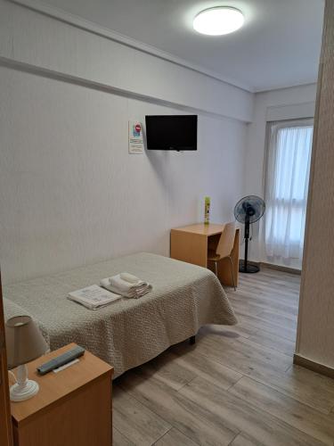 een kamer met een bed en een flatscreen-tv bij Pension Iruna in Santurce