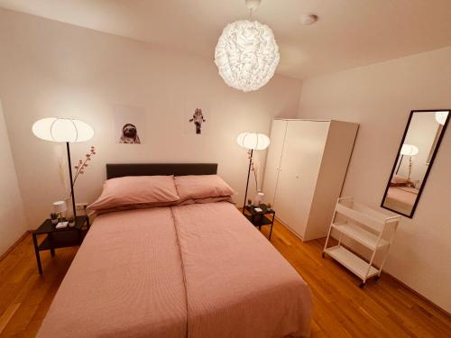 a bedroom with a large bed and two lamps at Ursula Rosé Collection an der Donau in Vienna