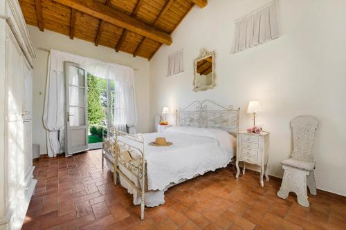 La CroceにあるHouse in the heart of Tuscany with A/C and pool!の白いベッドと窓のある寝室