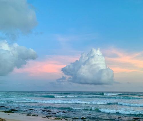 a cloud sitting on top of the ocean at Aldea bleu in Midigama