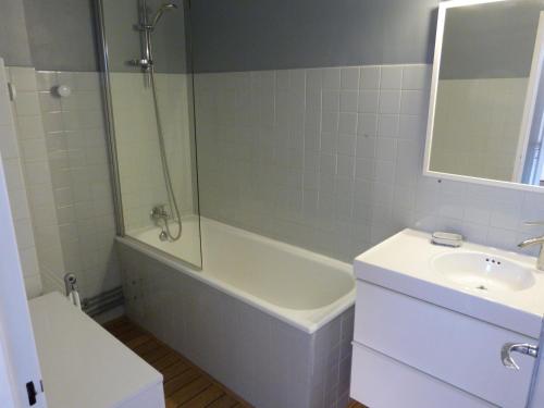 uma casa de banho com uma banheira, um lavatório e um chuveiro em Joli T2 au coeur de Praloup 1600 em Uvernet