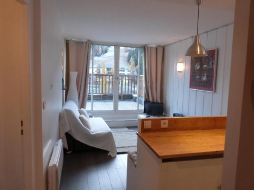 um quarto com uma cama, uma secretária e uma janela em Joli T2 au coeur de Praloup 1600 em Uvernet