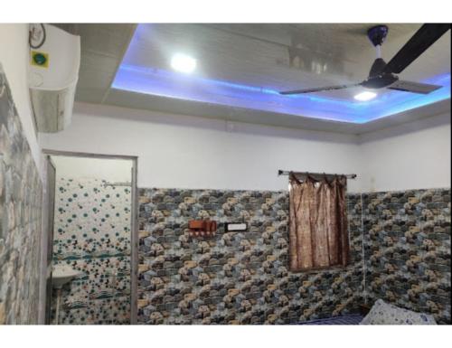 a bathroom with a shower curtain and a ceiling at Eeshwar Lodge, Patnagarh, Odisha 