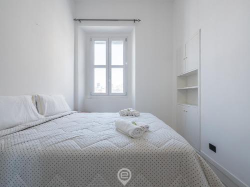 a white bedroom with a bed with towels on it at Port View Apartment in Cagliari