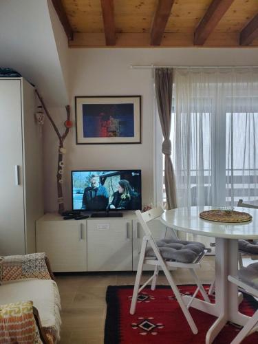salon z białym stołem i telewizorem w obiekcie Apartman Čaroban pogled Divcibare w mieście Divčibare