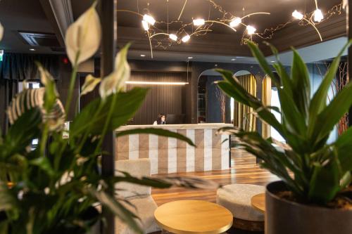 a dining room with a table and a potted plant at La Mansion Vi Vadi Hotel in Munich