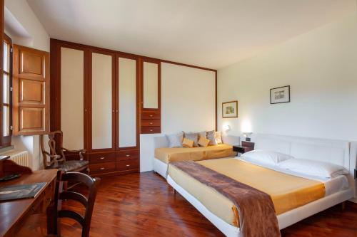 a bedroom with two beds and a table and a desk at Torrebianca Tuscany in Rignano sullʼArno