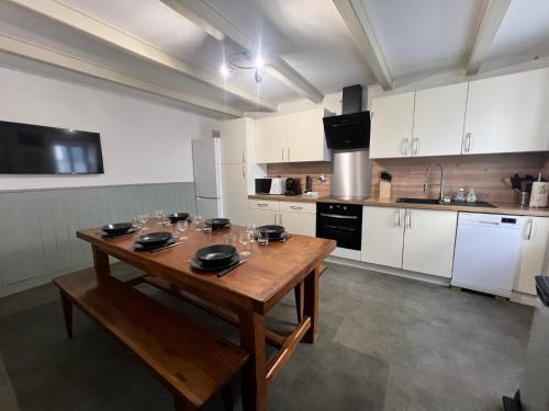 a kitchen with a wooden table with glasses on it at Le Phare des Baleines in La Flotte