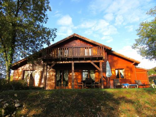 a log cabin with a porch and a deck at Tidy chalet in the woods of the beautiful Dordogne in Souillac
