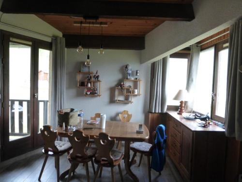 a dining room with a table and chairs and windows at Ventoux 24 in Enchastrayes