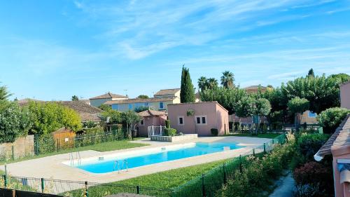 une maison avec une piscine dans une cour dans l'établissement Le Mazet Sooksabai, confort, charme et découverte en Petite Camargue, à Saint-Laurent-dʼAigouze